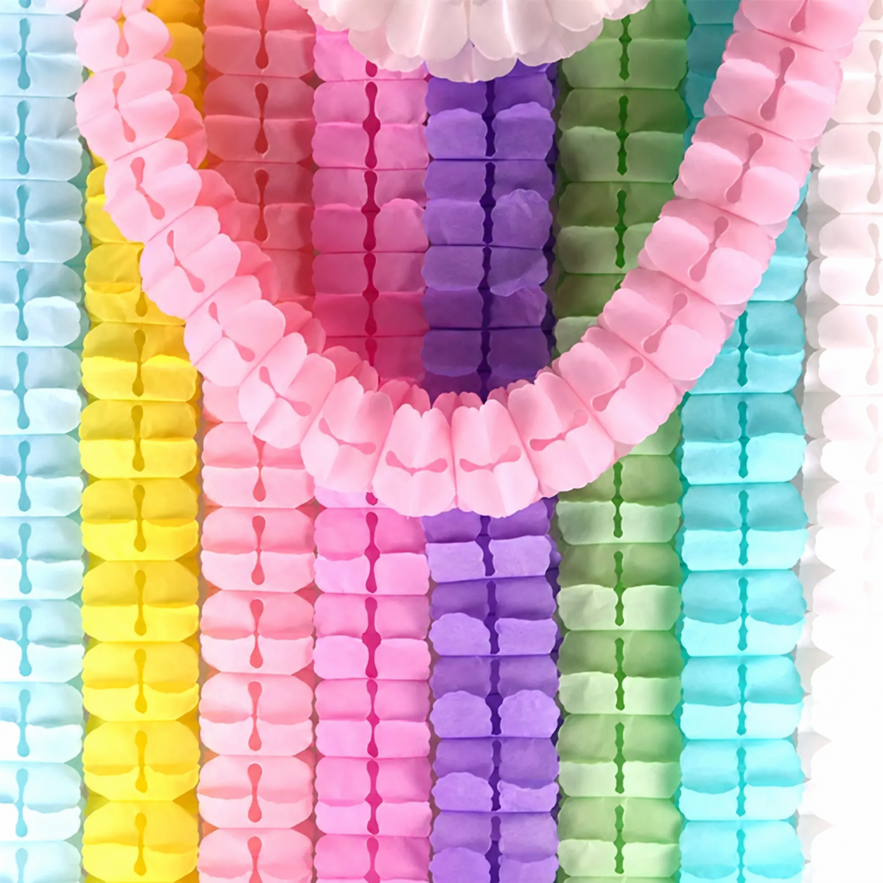 Guirlandas de papel em verde menta, rosa-claro e lilás-claro